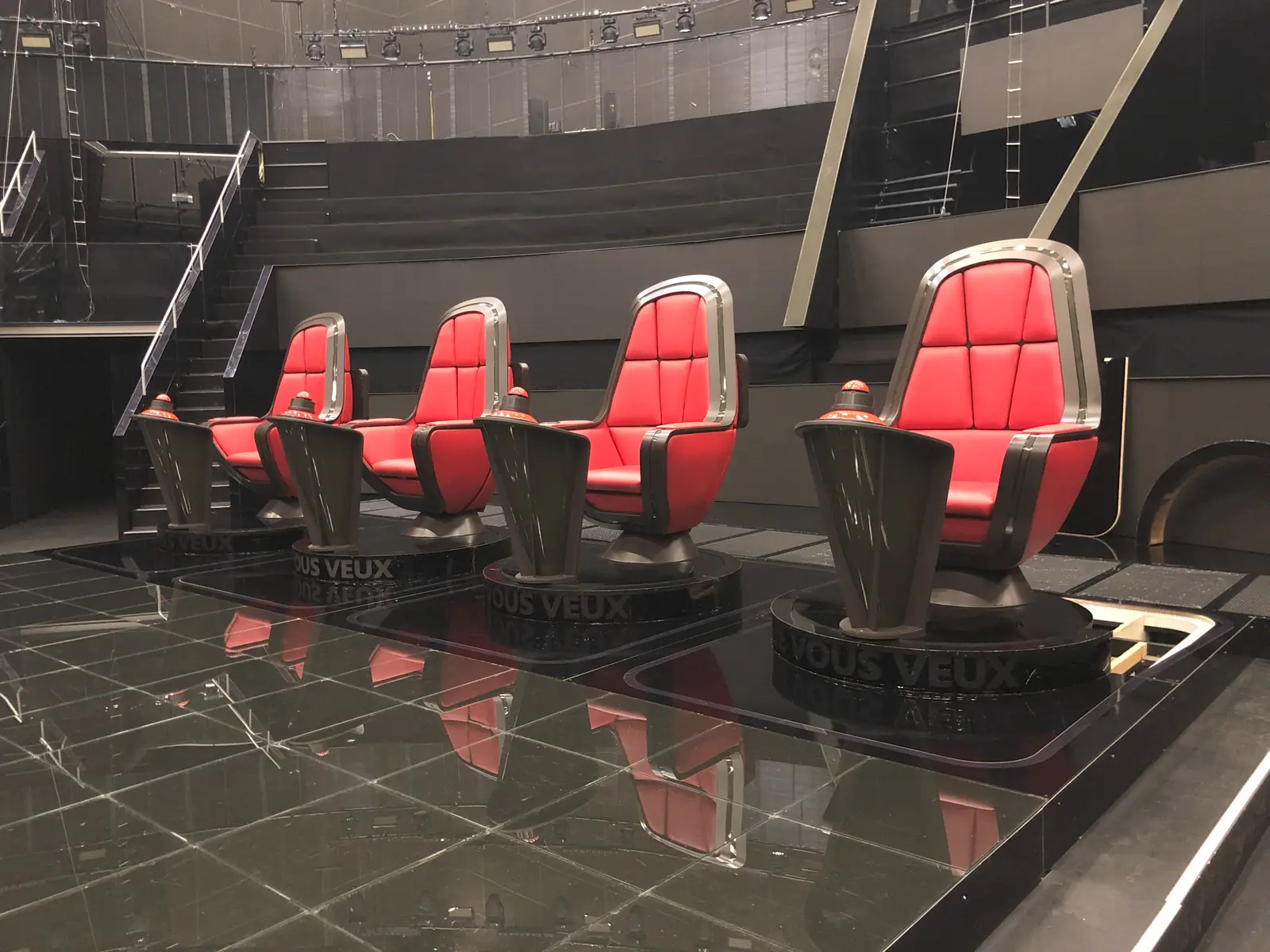 Rangée de fauteuils rouges sur mesure, montés sur socles, dans une installation