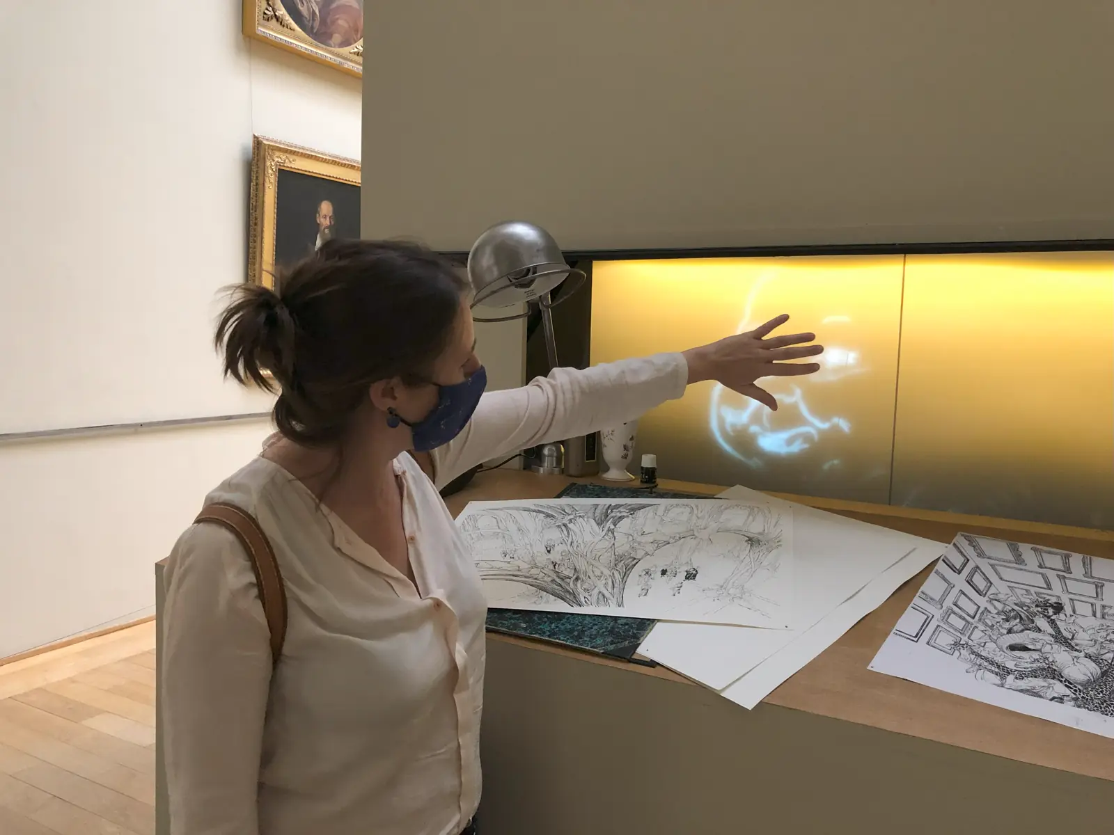 Visiteuse interagissant de la main avec un hologramme tactile dans une exposition