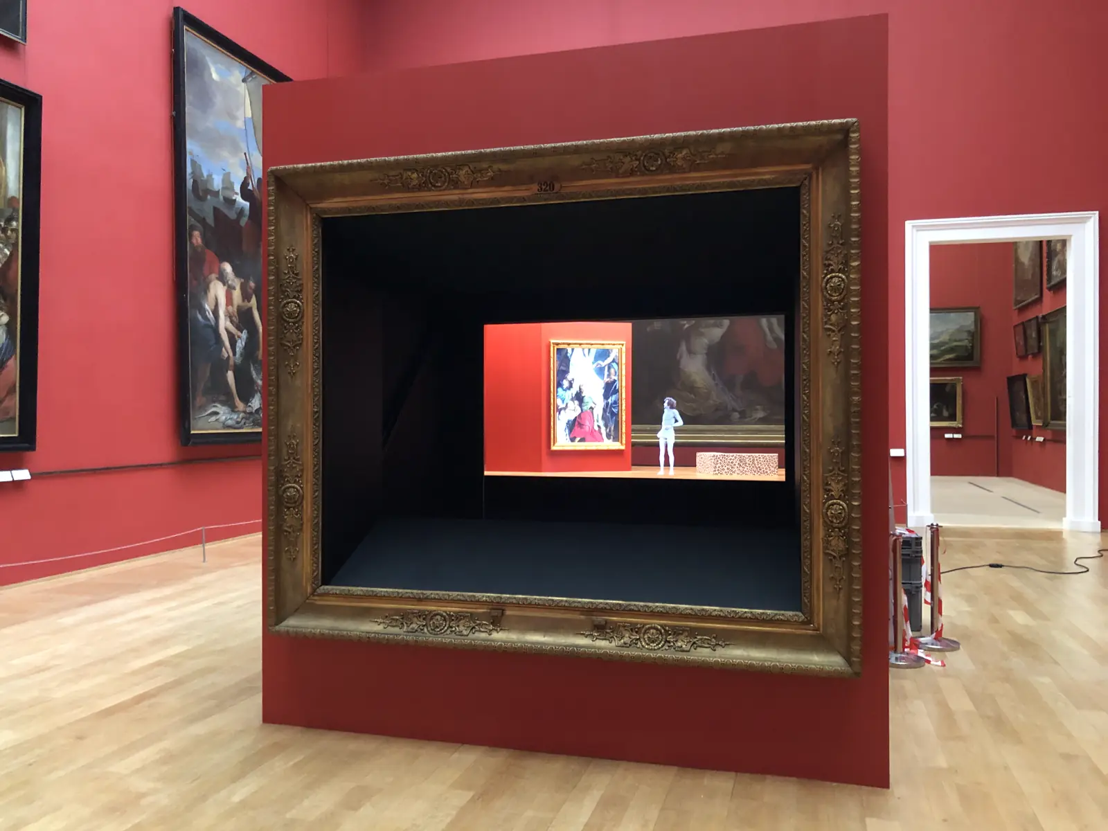 Scénographie de musée : grand cadre doré encadrant un dispositif encastré