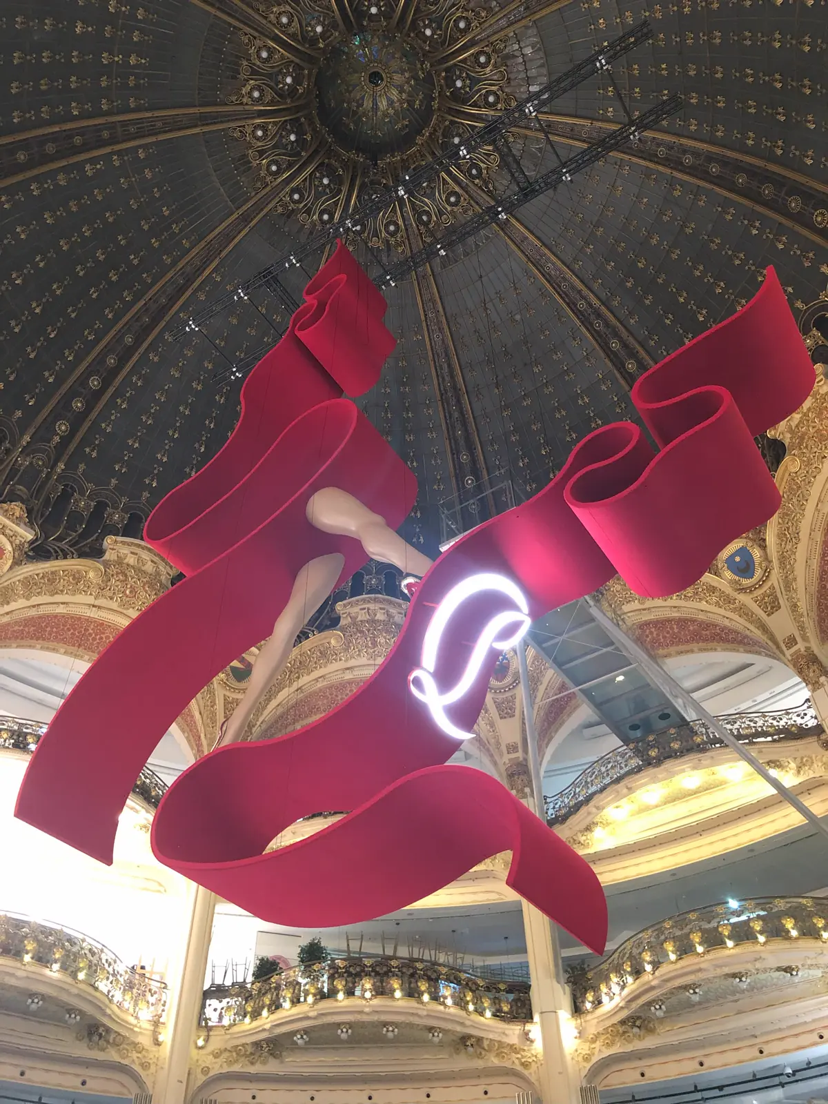 Sculpture textile rouge suspendue sous une coupole ornée